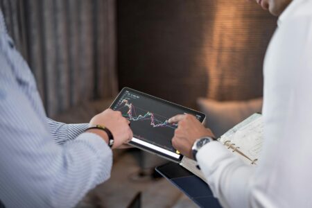 Professional using tablet device at modern office desk with documents