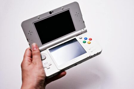 Why Retro Gaming Handhelds Are Outselling Modern Portable Consoles Person holding a portable gaming device with colorful screen displaying retro video game