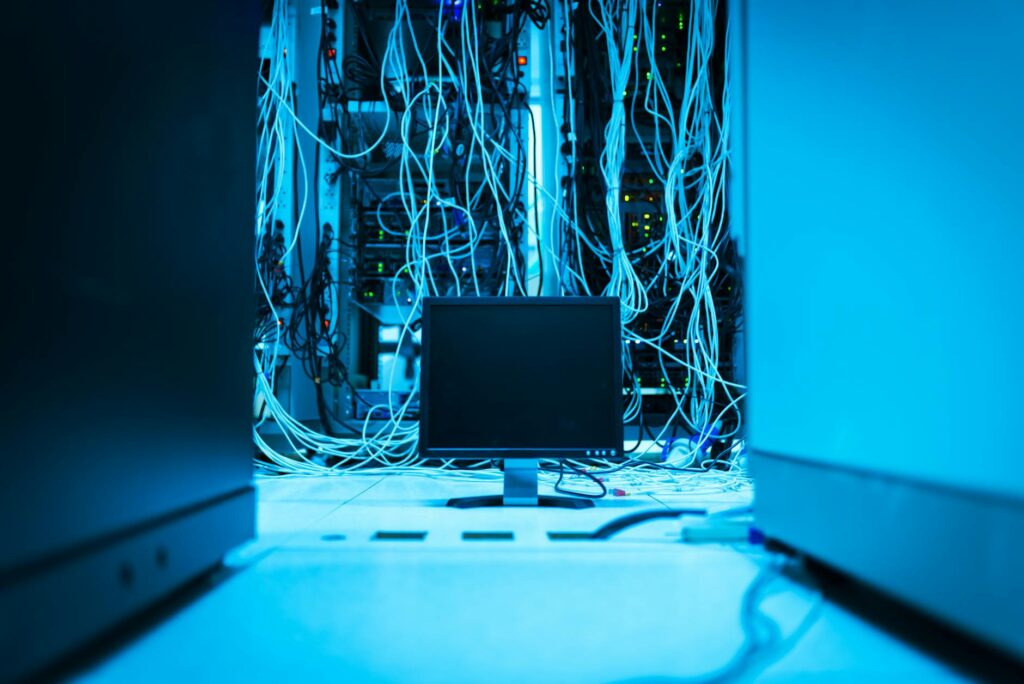Why Software Developers Are Switching from Docker to Podman for Container Management Modern server room with rows of computing equipment and networking infrastructure