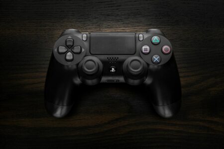 Close-up of a gaming controller on a dark surface showing buttons and analog sticks