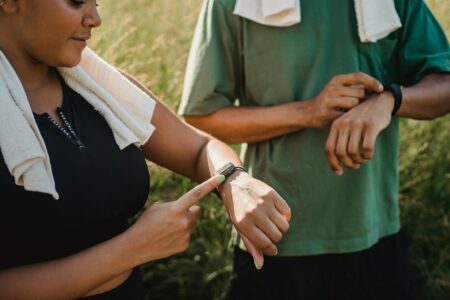 Why Fitness Trackers Are Adding Blood Glucose Monitoring Without Needles Person wearing a black fitness tracker on their wrist displaying health metrics