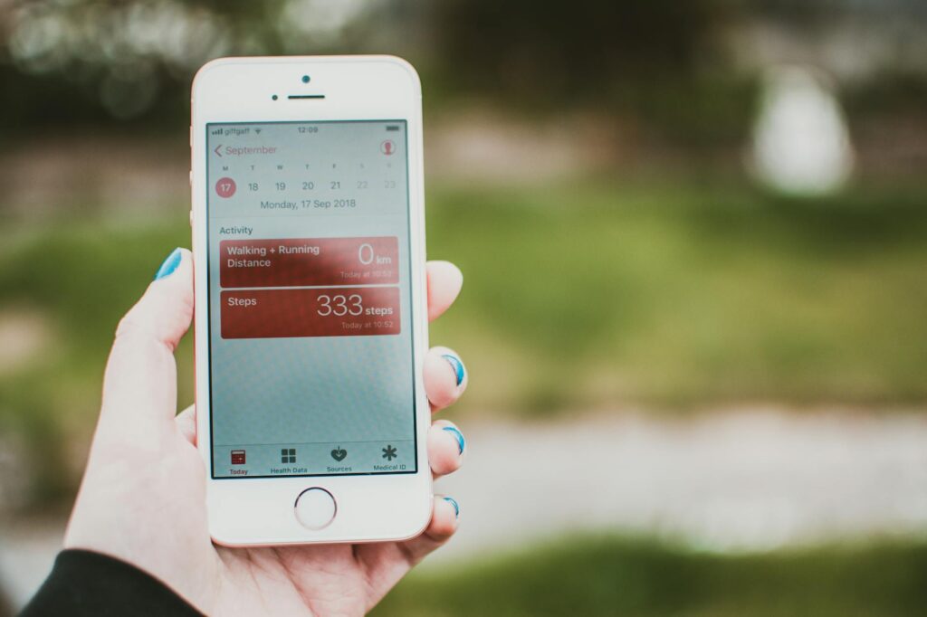 How Smartphone Manufacturers Are Adding Temperature Sensors for Health Tracking Person using health monitoring app on smartphone screen