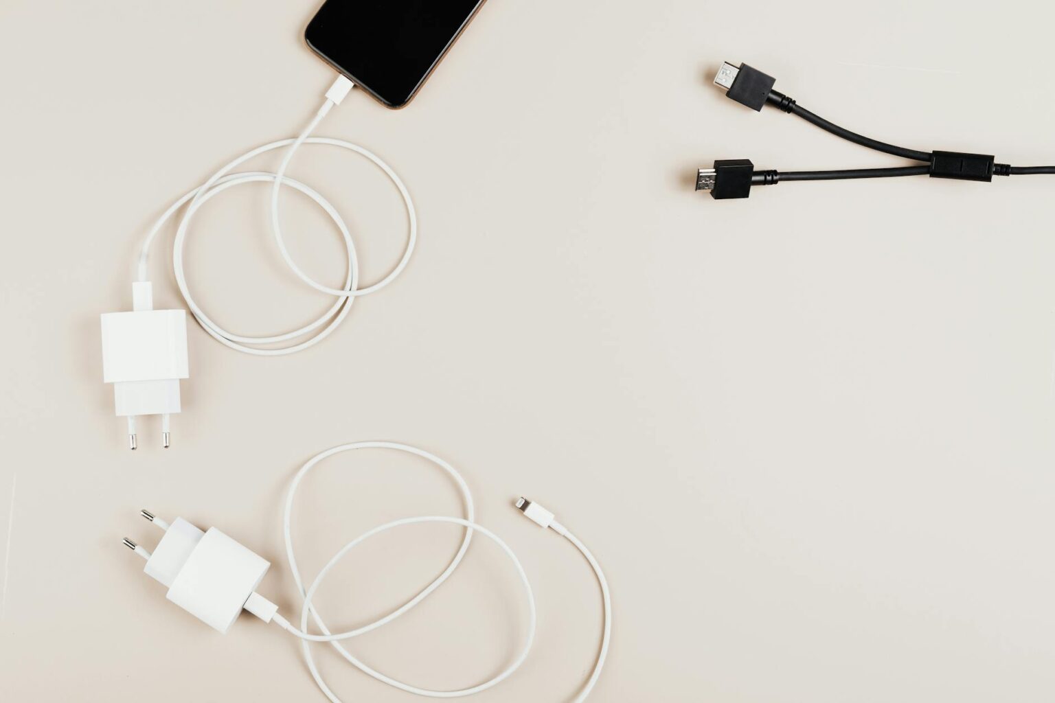 Modern smartphone connected to fast charging cable on desk