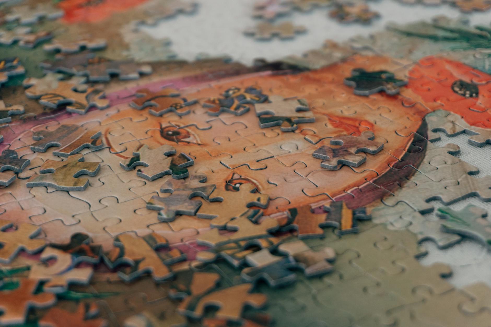 Close-up view of colorful puzzle pieces being assembled by hands