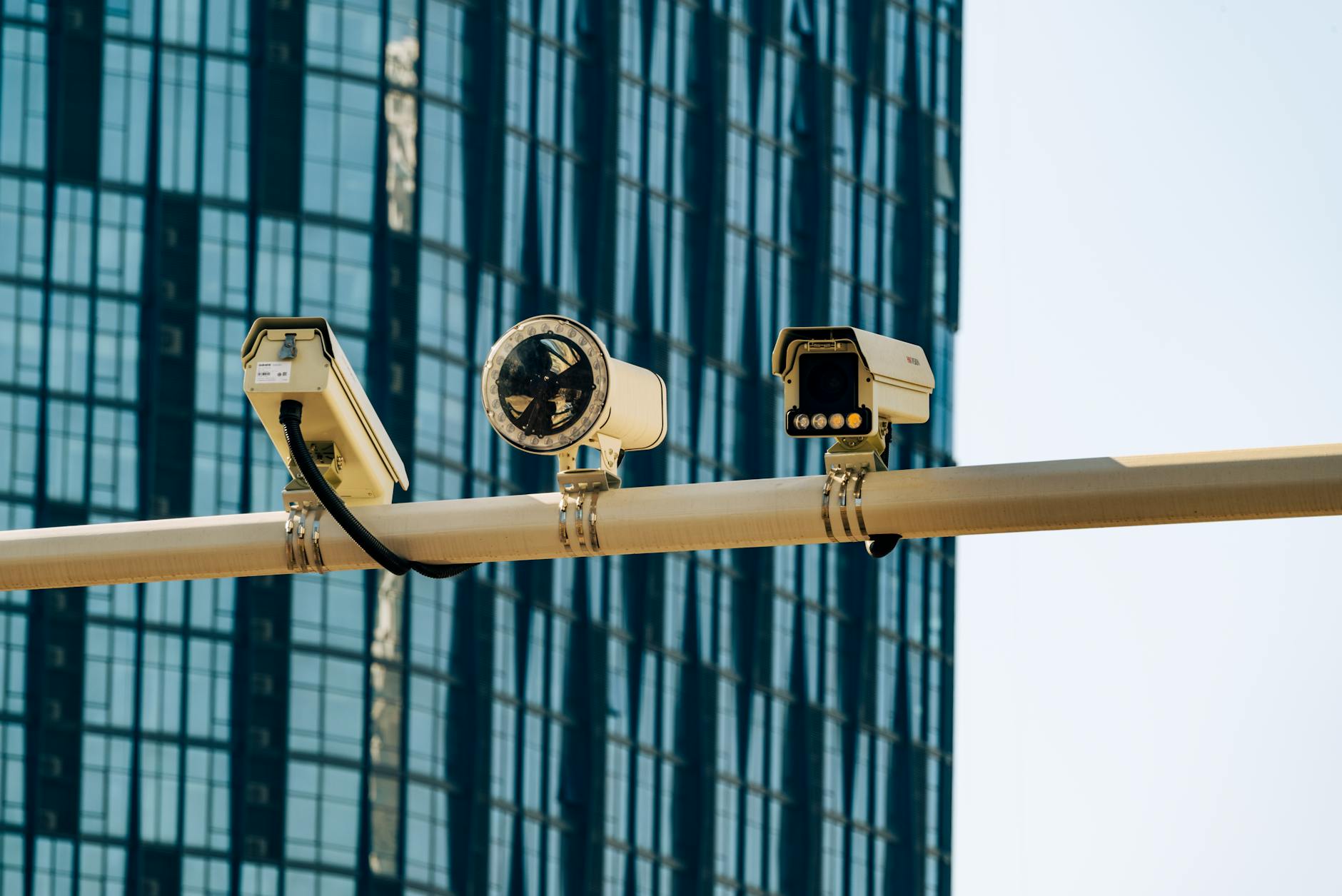 White wireless security camera mounted on exterior wall of residential home