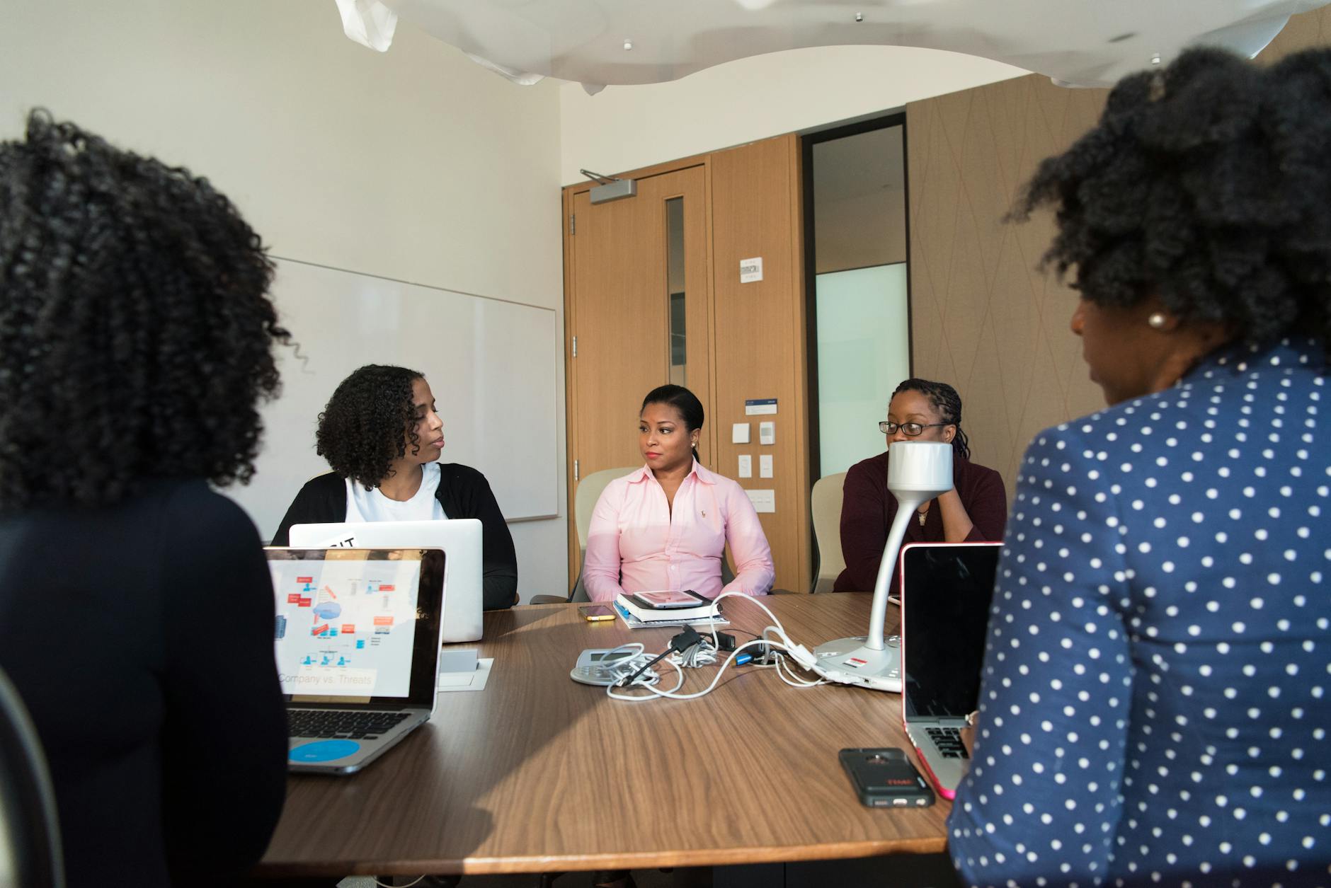 Business professionals discussing technology solutions in modern conference room