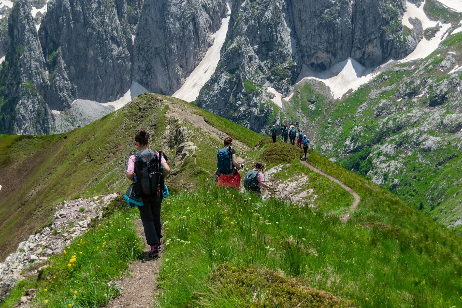 Person hiking on remote mountain trail where satellite messaging provides emergency connectivity