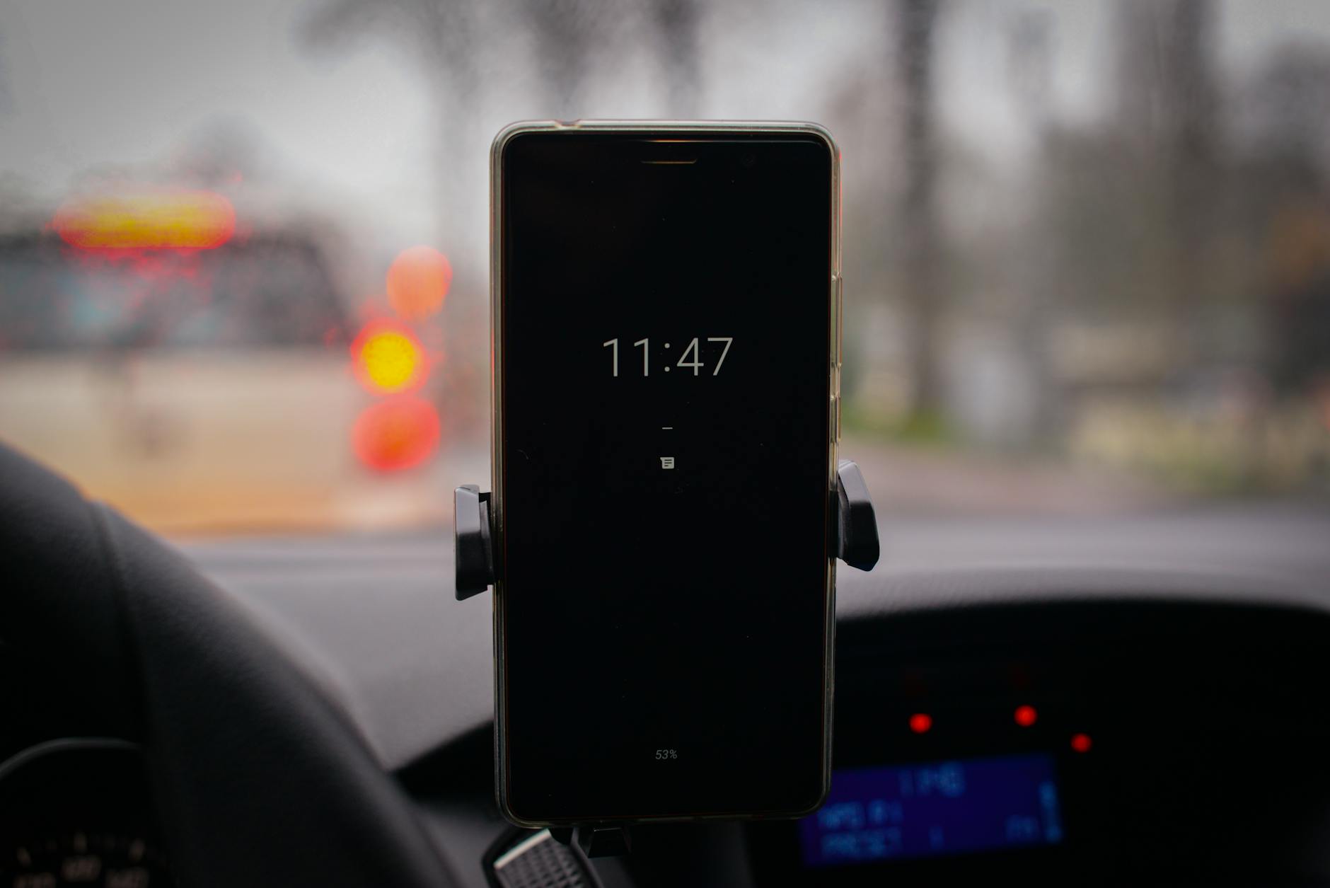 Smartphone mounted in car showing navigation and app interface