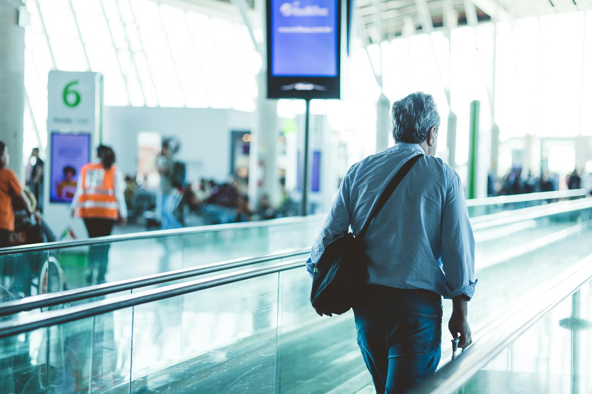 Diverse travelers with luggage walking through airport terminal