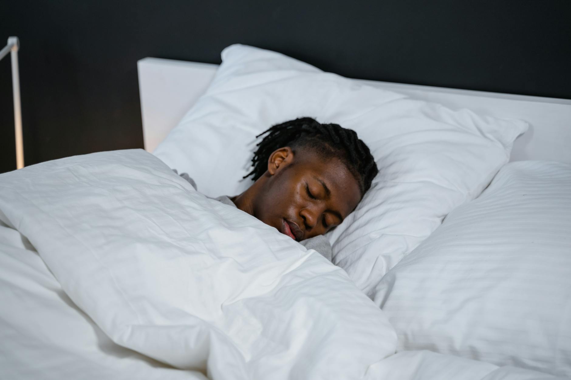 Professional athlete sleeping peacefully in bed with modern sleep optimization technology visible