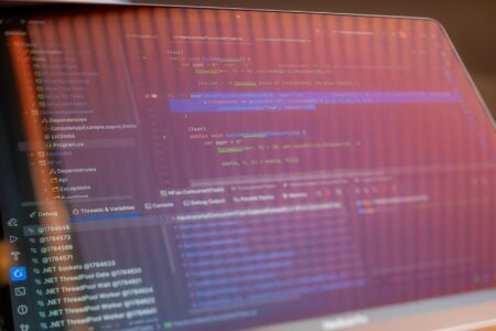 GitHub Copilot Usage Drops as Developers Switch to Claude for Code Reviews Software developer working on code at computer with multiple monitors showing programming interfaces