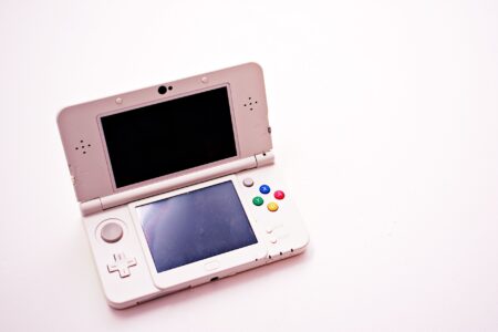 Nintendo Switch 2 Pre-Orders Are Cannibalizing Steam Deck Sales Person holding a handheld gaming console while relaxing on a couch