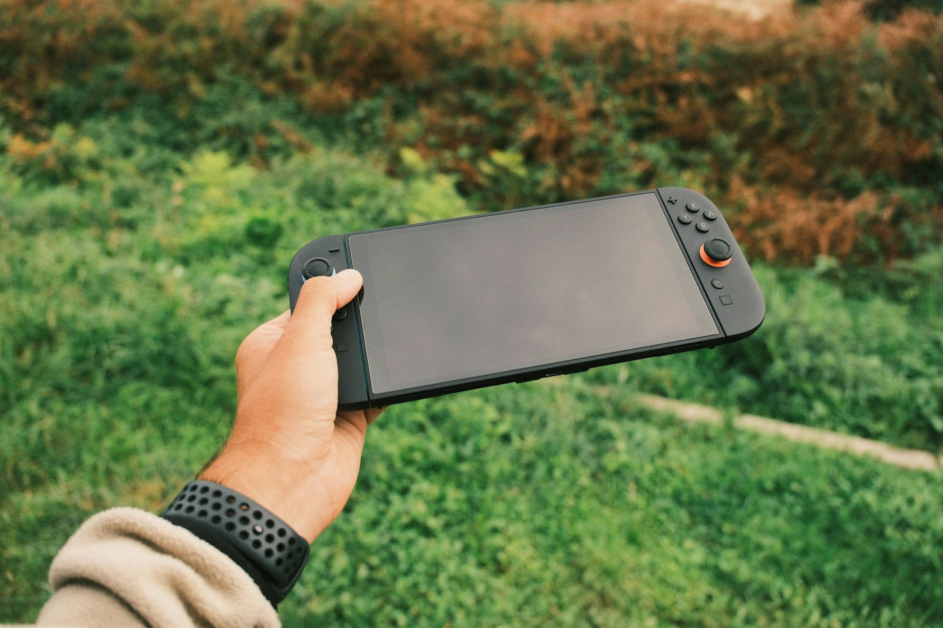 Person holding a portable gaming device with both hands showing button layout