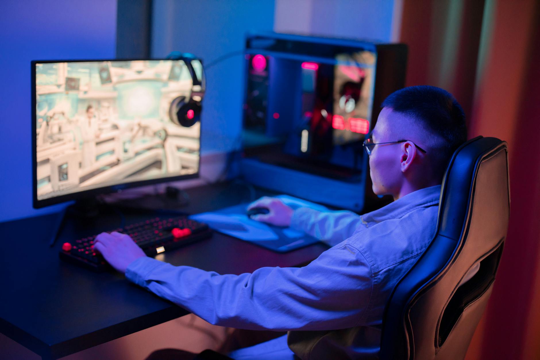 A lit gaming PC desk setup with monitor and peripherals, representing competitive PC gaming