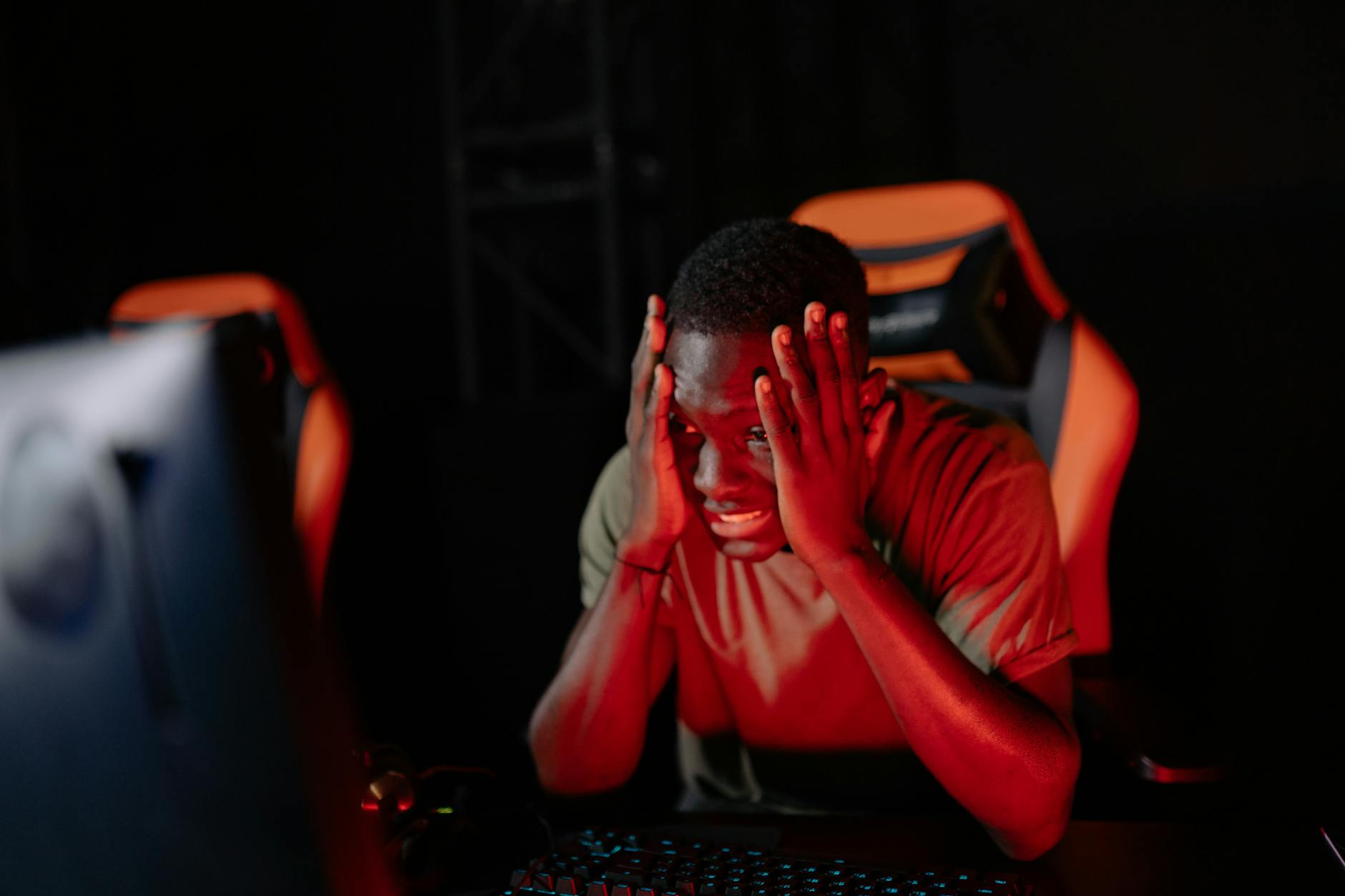 A gamer looking frustrated at a monitor, representing player burnout in competitive games