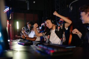 Riot’s League of Legends Veteran Players Are Defecting to Deadlock A dark gaming setup with multiple monitors glowing, representing competitive PC gaming culture