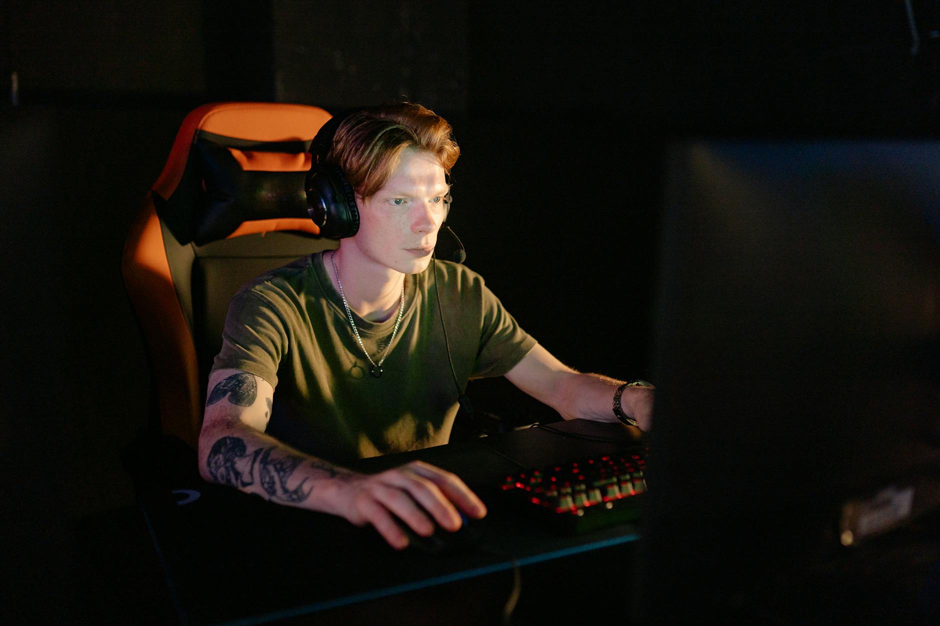 A person sitting at a gaming setup, suggesting a buyer holding off on a purchase decision