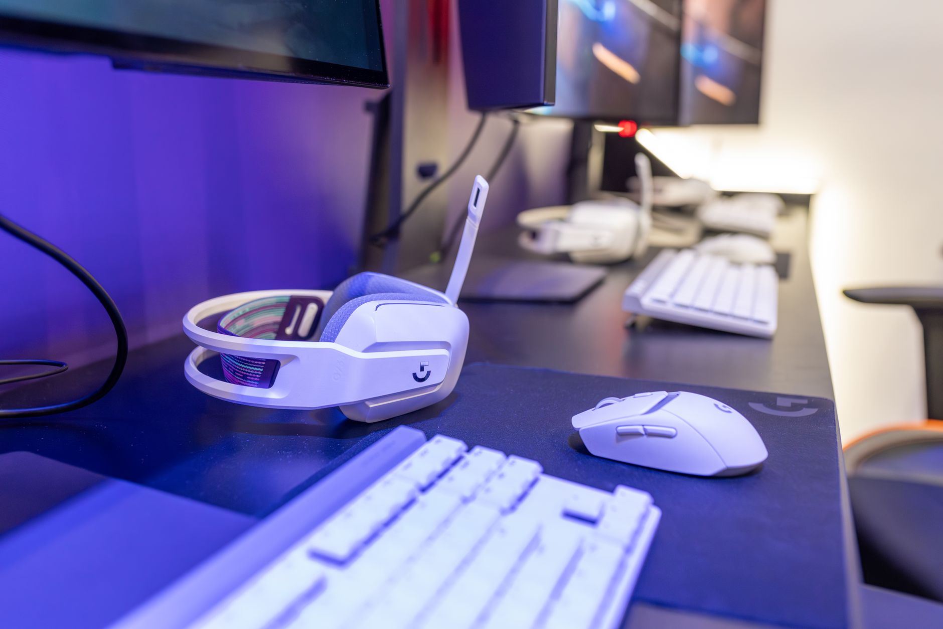 A modern gaming PC setup with multiple screens in a dimly lit room