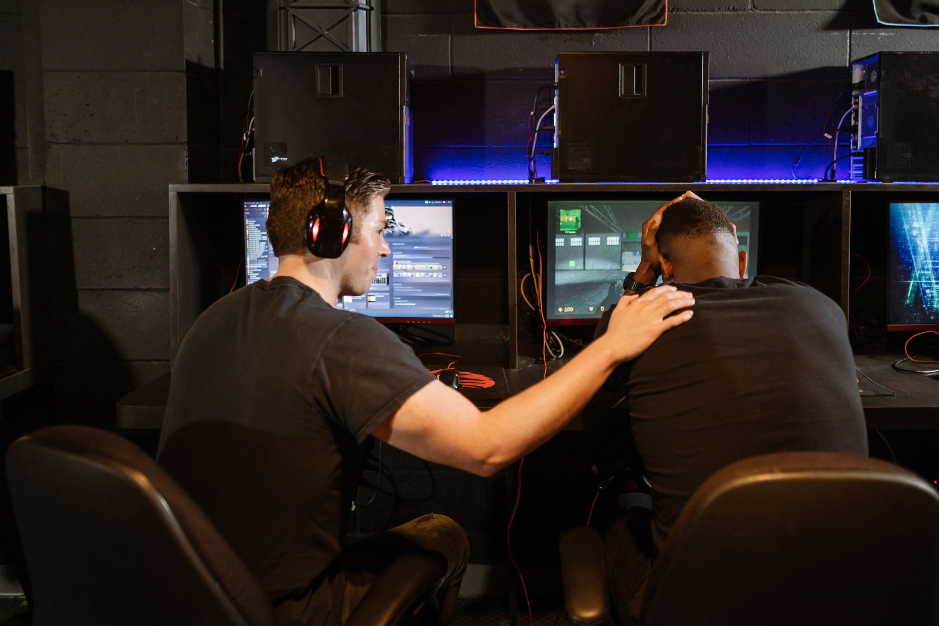 A gamer sitting at a desk looking frustrated in front of a computer screen