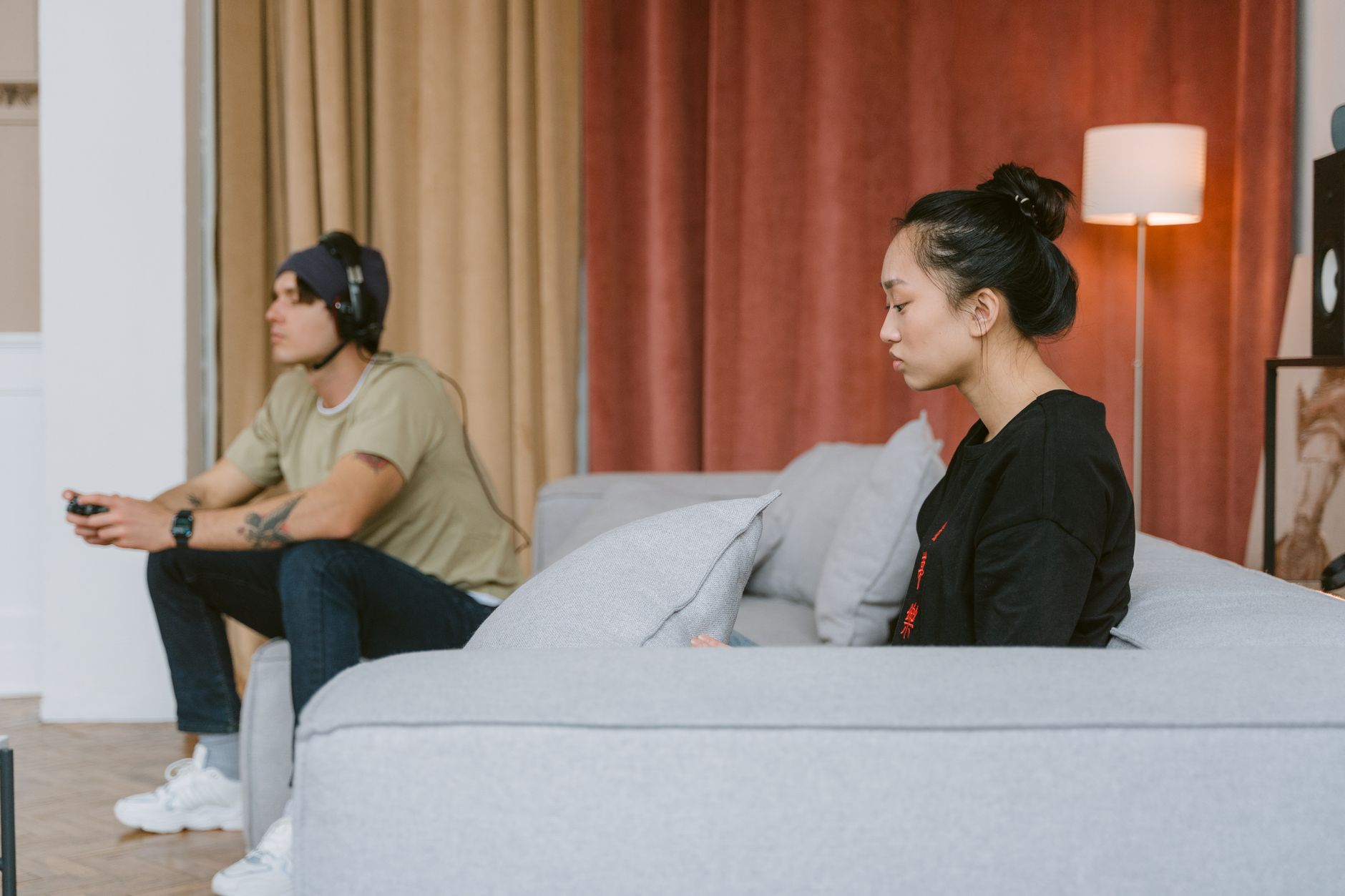 A person playing a handheld game console while seated on a couch at home
