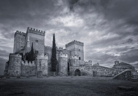 A dark, atmospheric gothic castle surrounded by fog, evoking the visual tone of Resident Evil Village