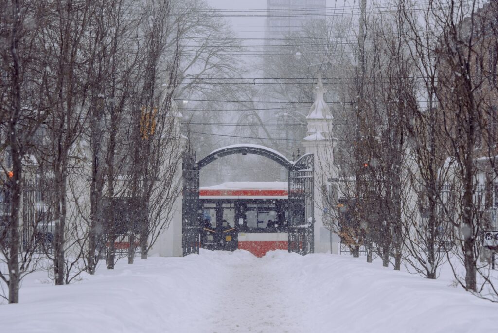 A snow-covered mountain path with a traditional torii gate, evoking the setting of Ghost of Yotei