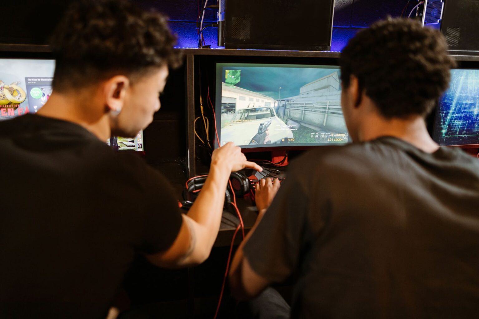 A gaming monitor displaying a hero shooter game in a dark room setup