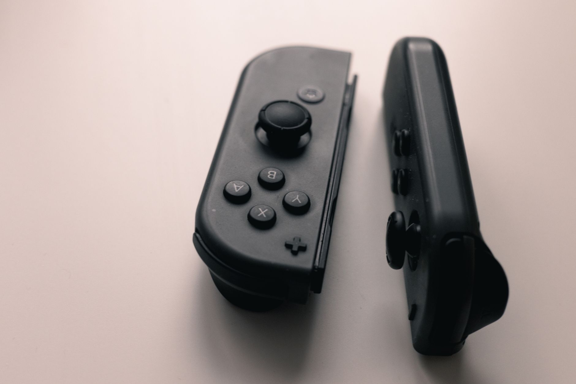 Close-up of a gaming controller resting on a surface, symbolizing player engagement and console gaming culture