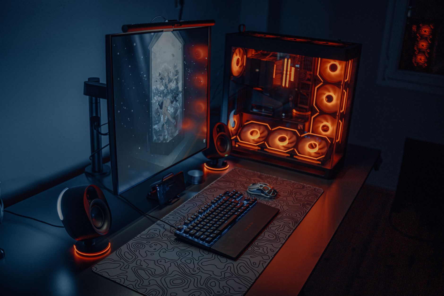A PC gaming desk setup with multiple screens and RGB lighting