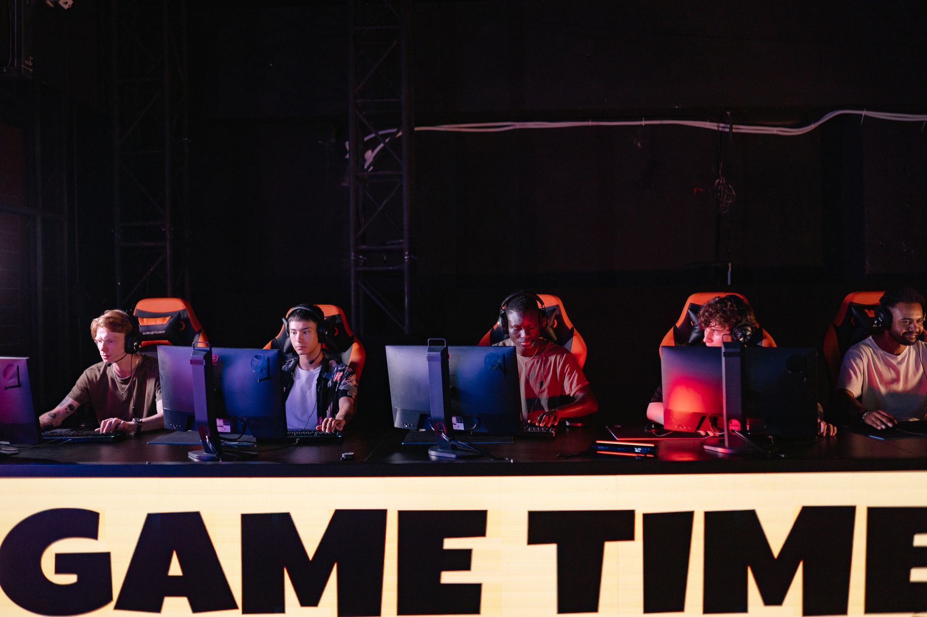 Players competing at a gaming tournament with monitors and controllers