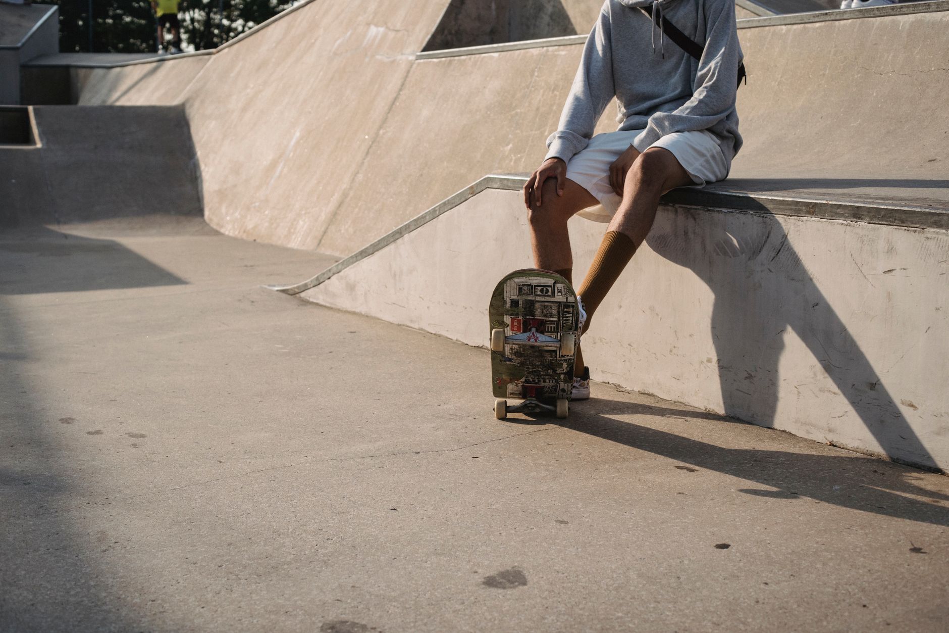 Empty concrete skate park with ramps and rails, reflecting the skateboarding community waiting for a new game