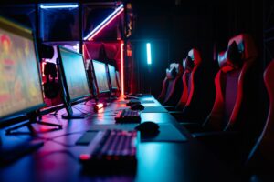 Capcom’s Monster Hunter Wilds Surge Is Cooling World Replays A dark gaming setup with a glowing monitor, representing intense gaming sessions in Monster Hunter Wilds