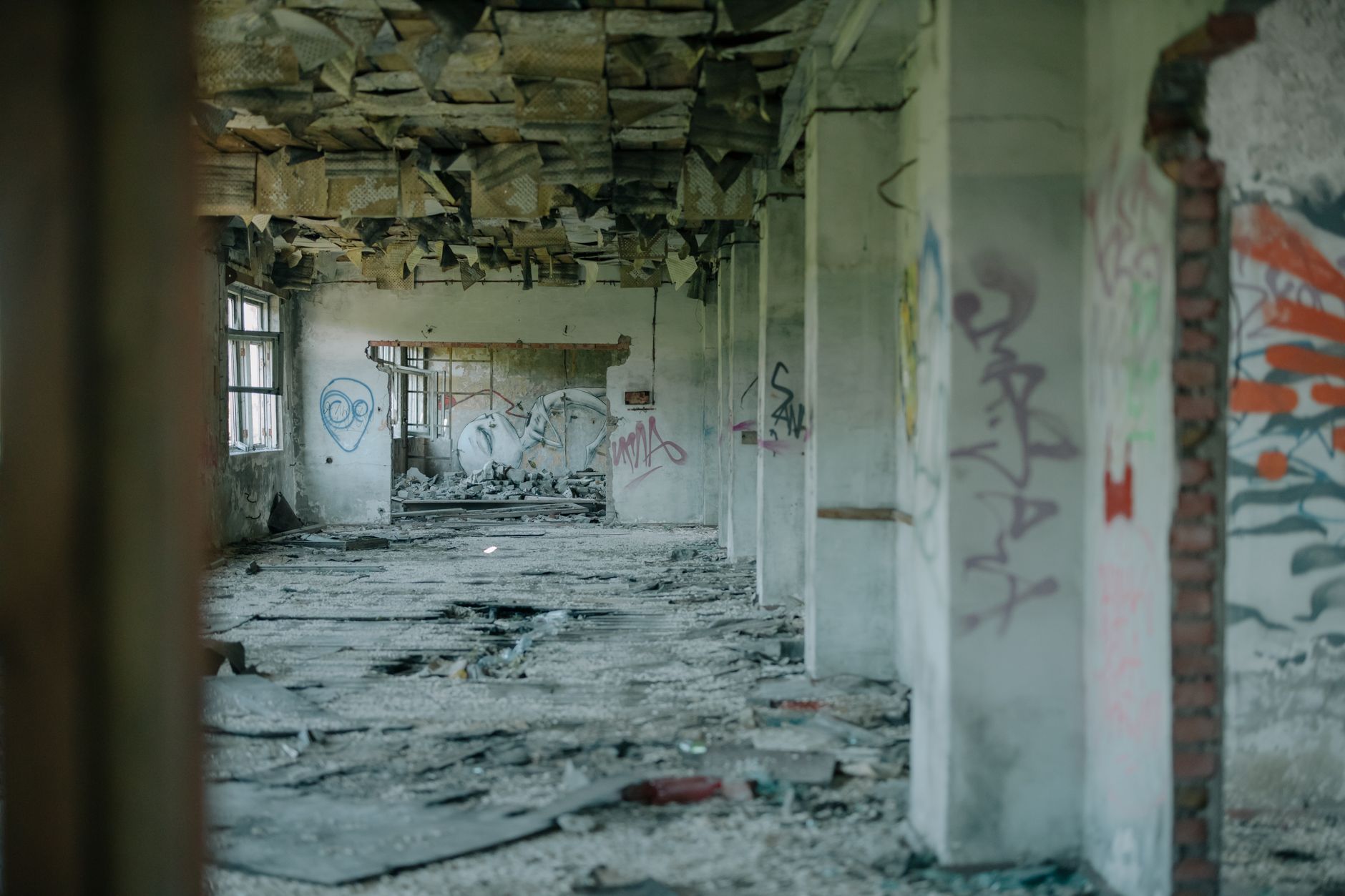 Interior of a decaying abandoned building with peeling walls and low lighting