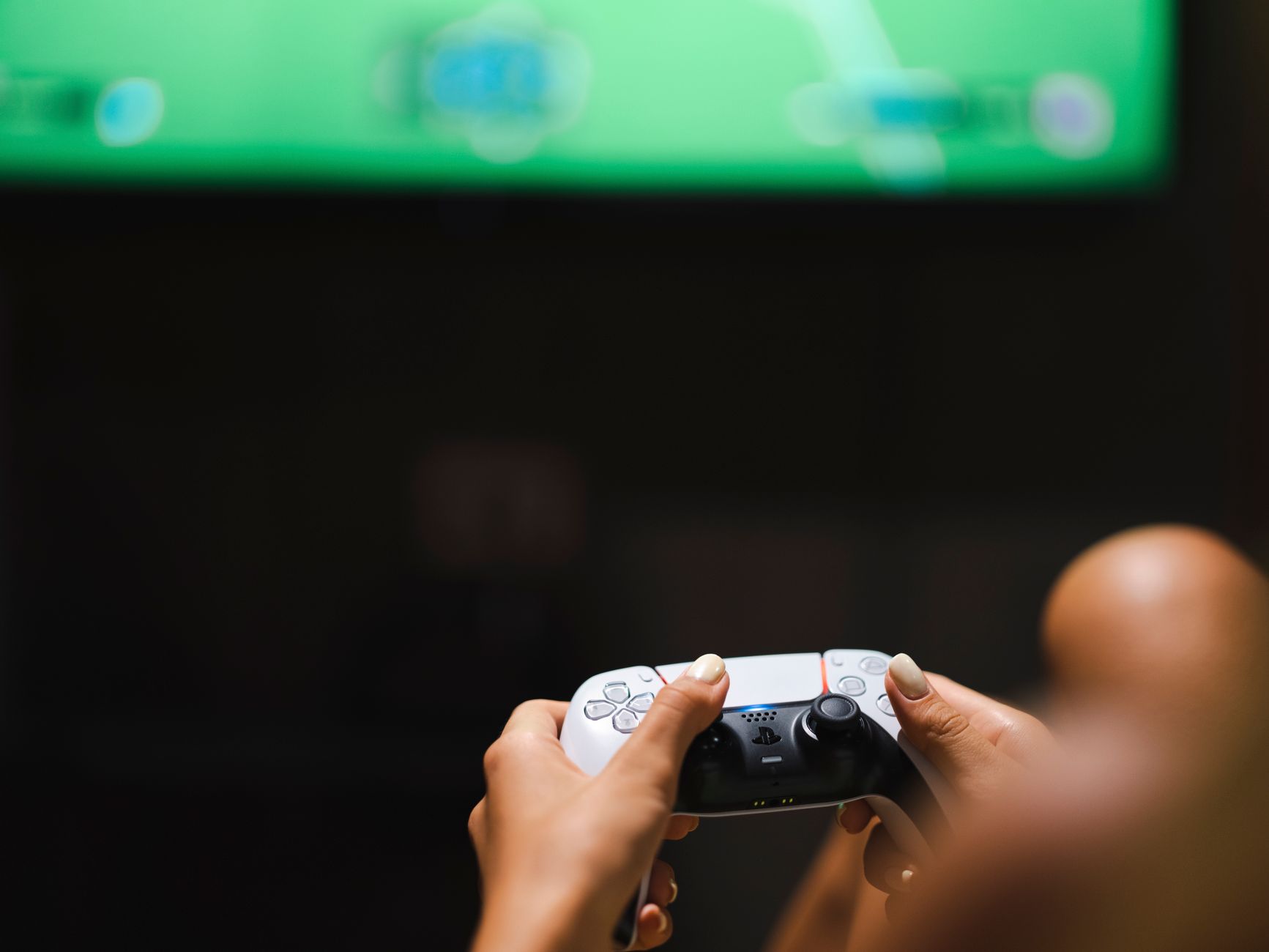 Person playing a console game in a dimly lit room