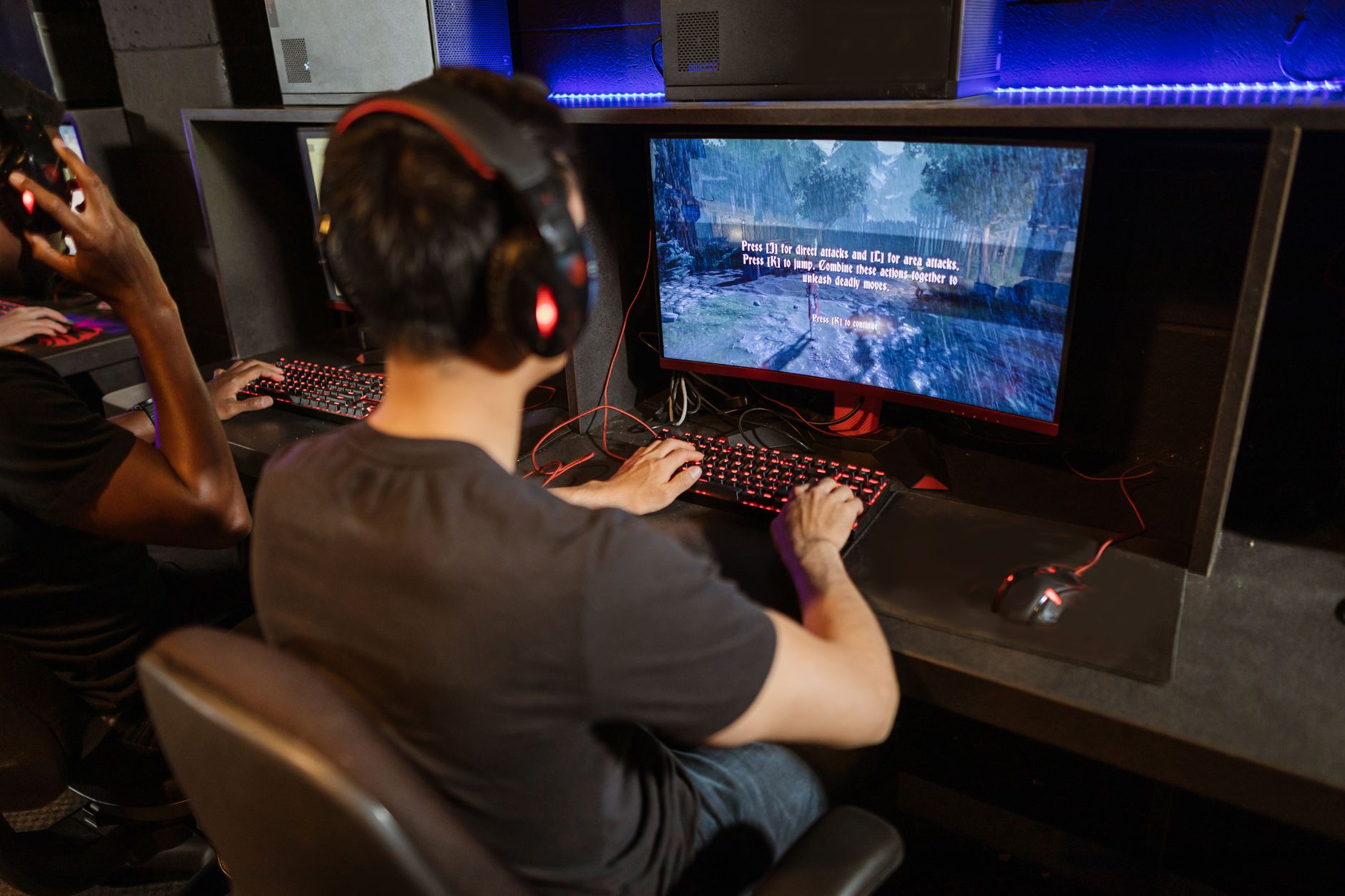 A player sitting at a monitor engaged with an online multiplayer game
