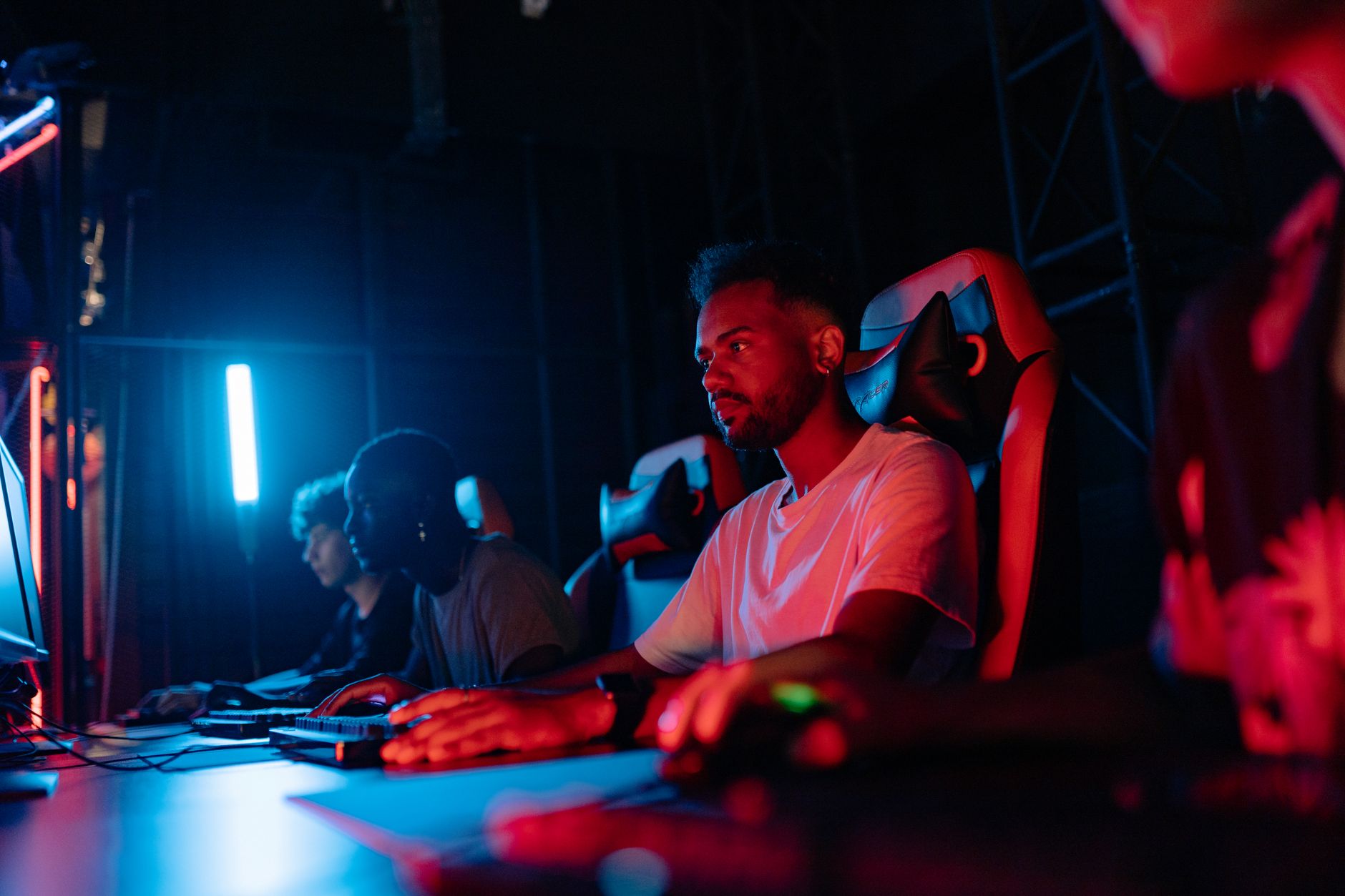 Person playing a video game on a large screen in a darkened room