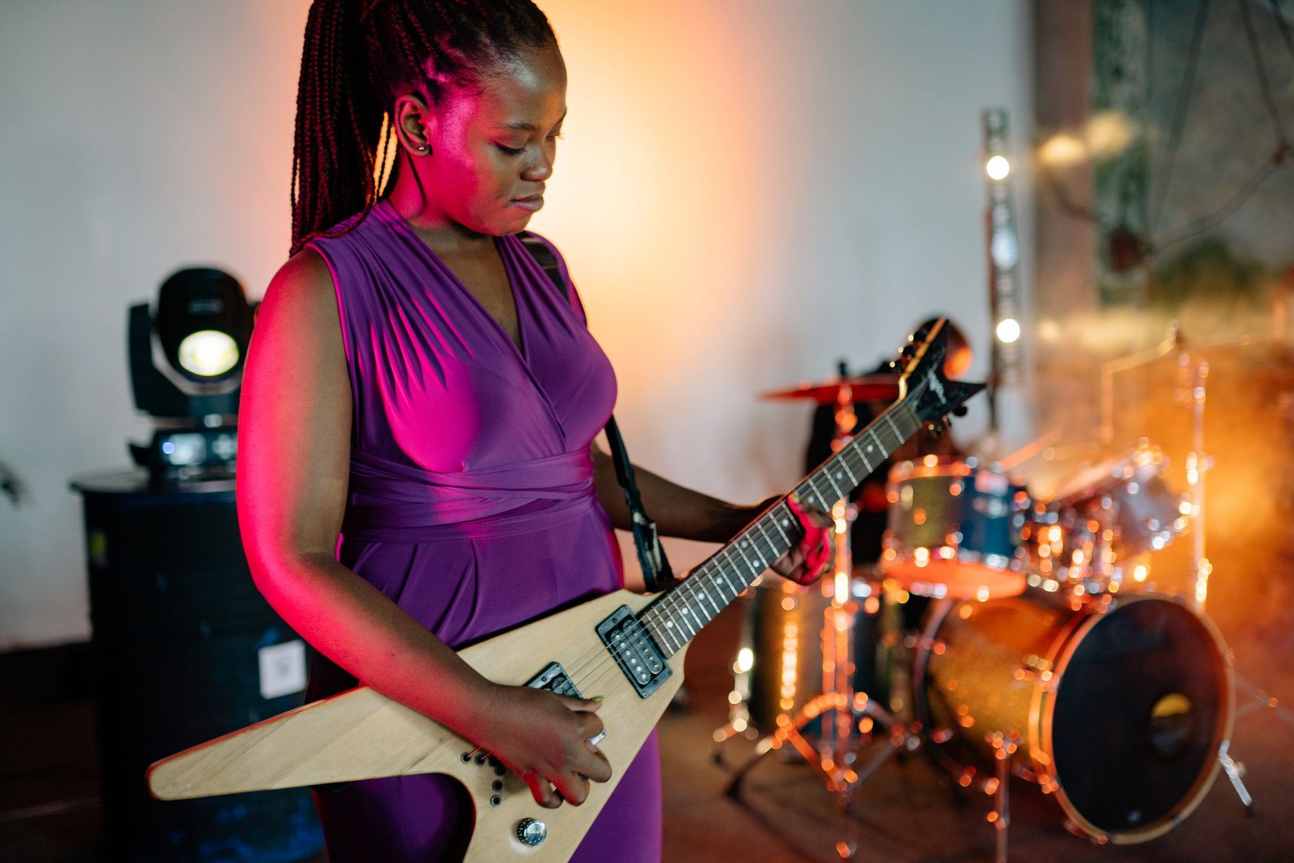 Person playing electric guitar on a performance stage
