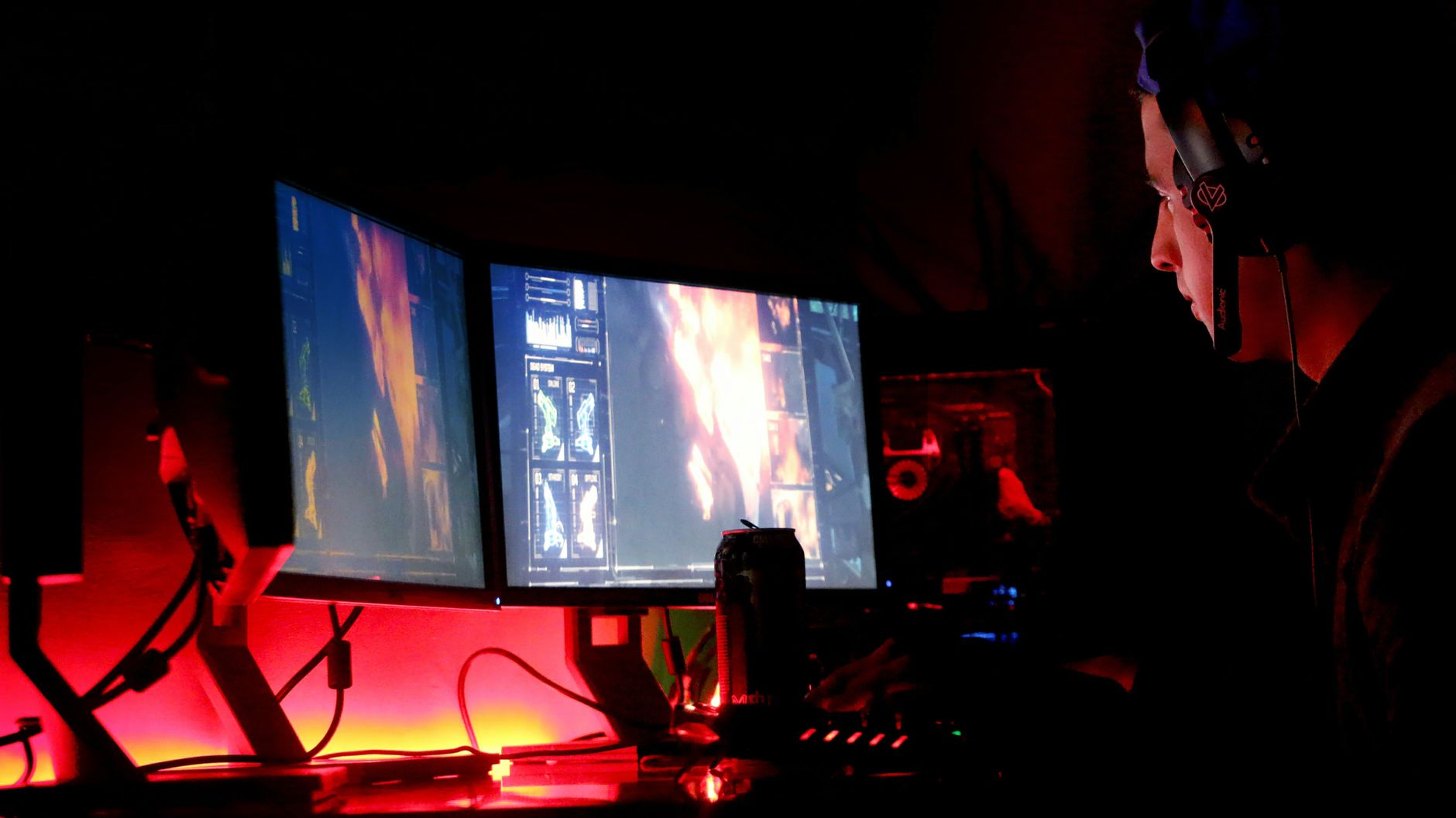 Focused gamer playing on a screen in a dimly lit room
