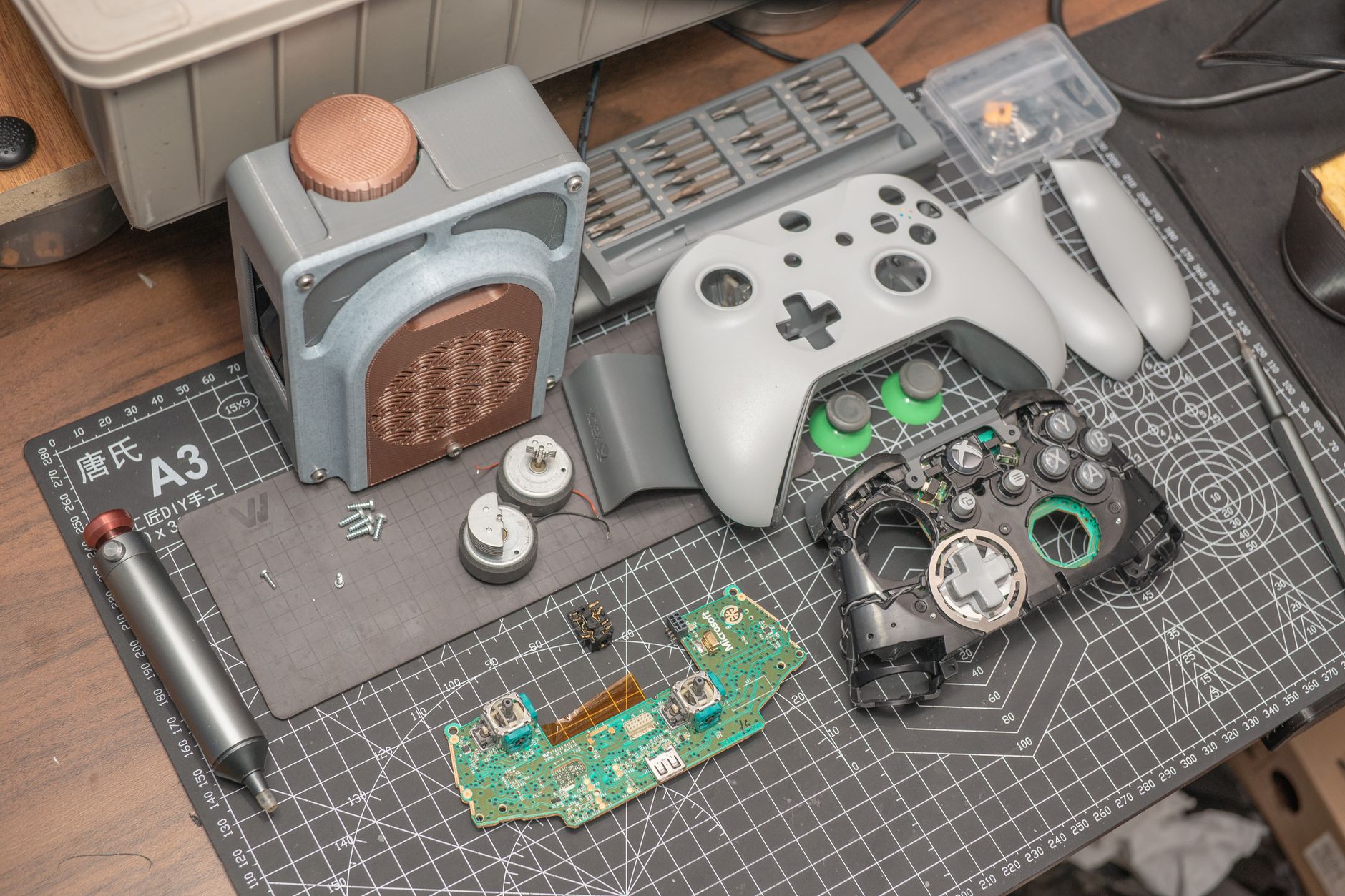 A gaming controller resting on a desk beside a lit monitor