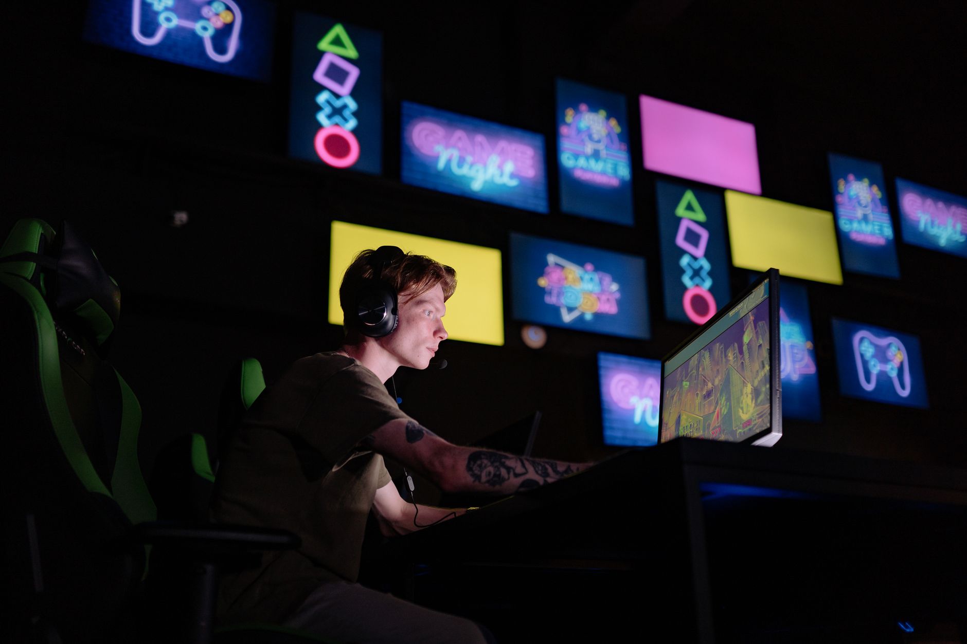 A person playing a video game on a large monitor in a dark room