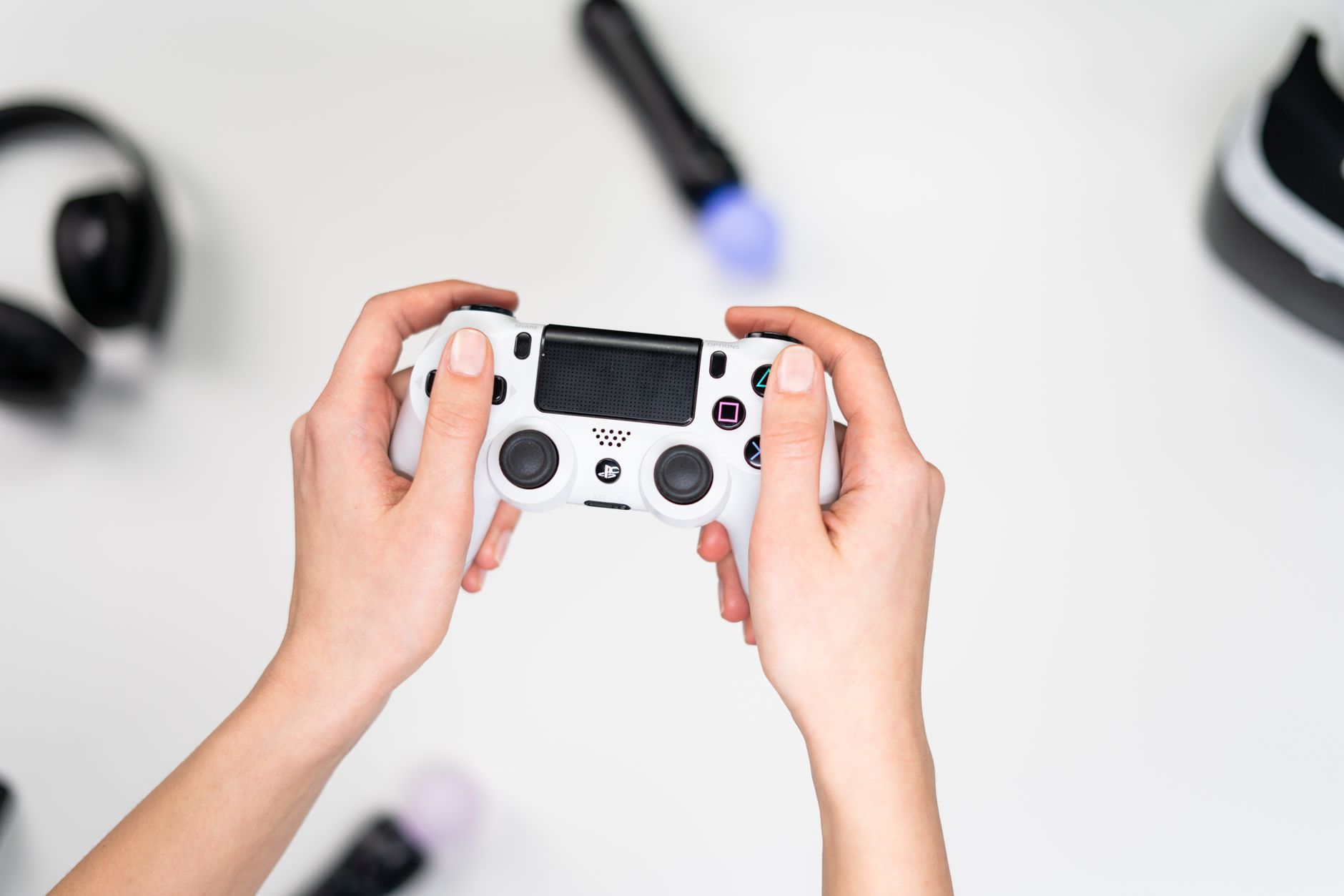 Person holding a game controller in a dimly lit room