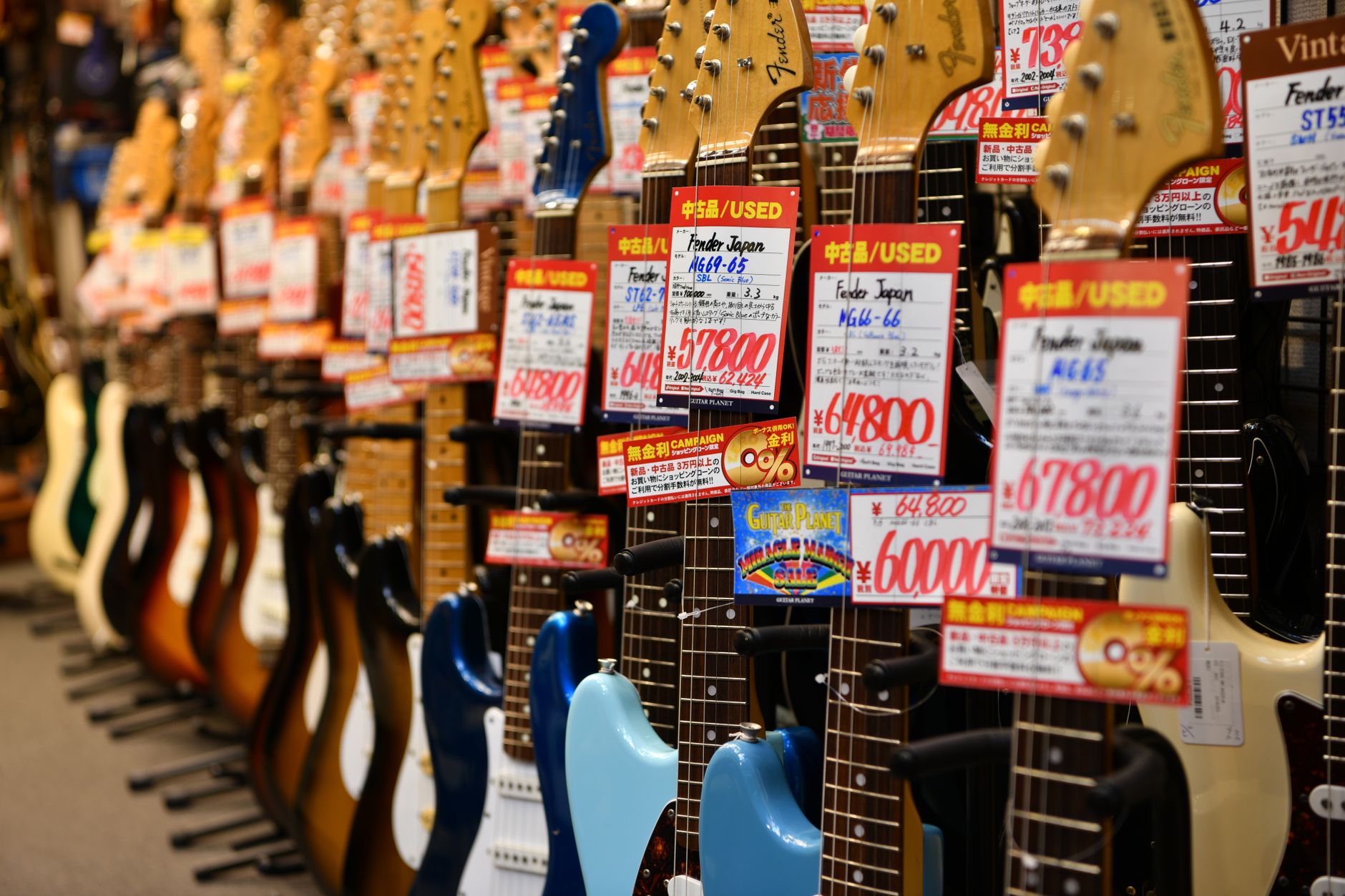 A collection of electric guitars hanging on a wall, representing the music gaming culture