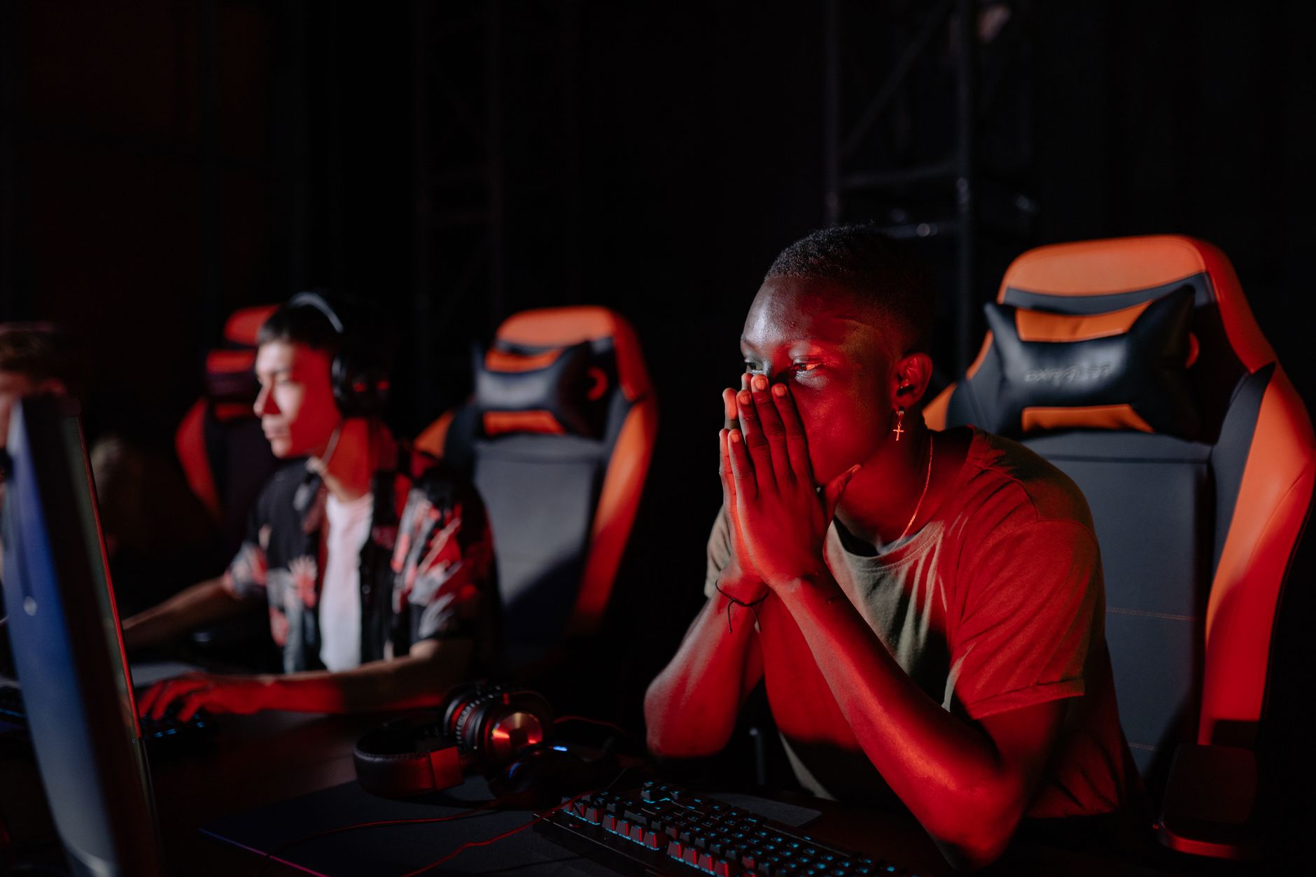 A person sitting at a desk looking at a screen with a frustrated or impatient expression