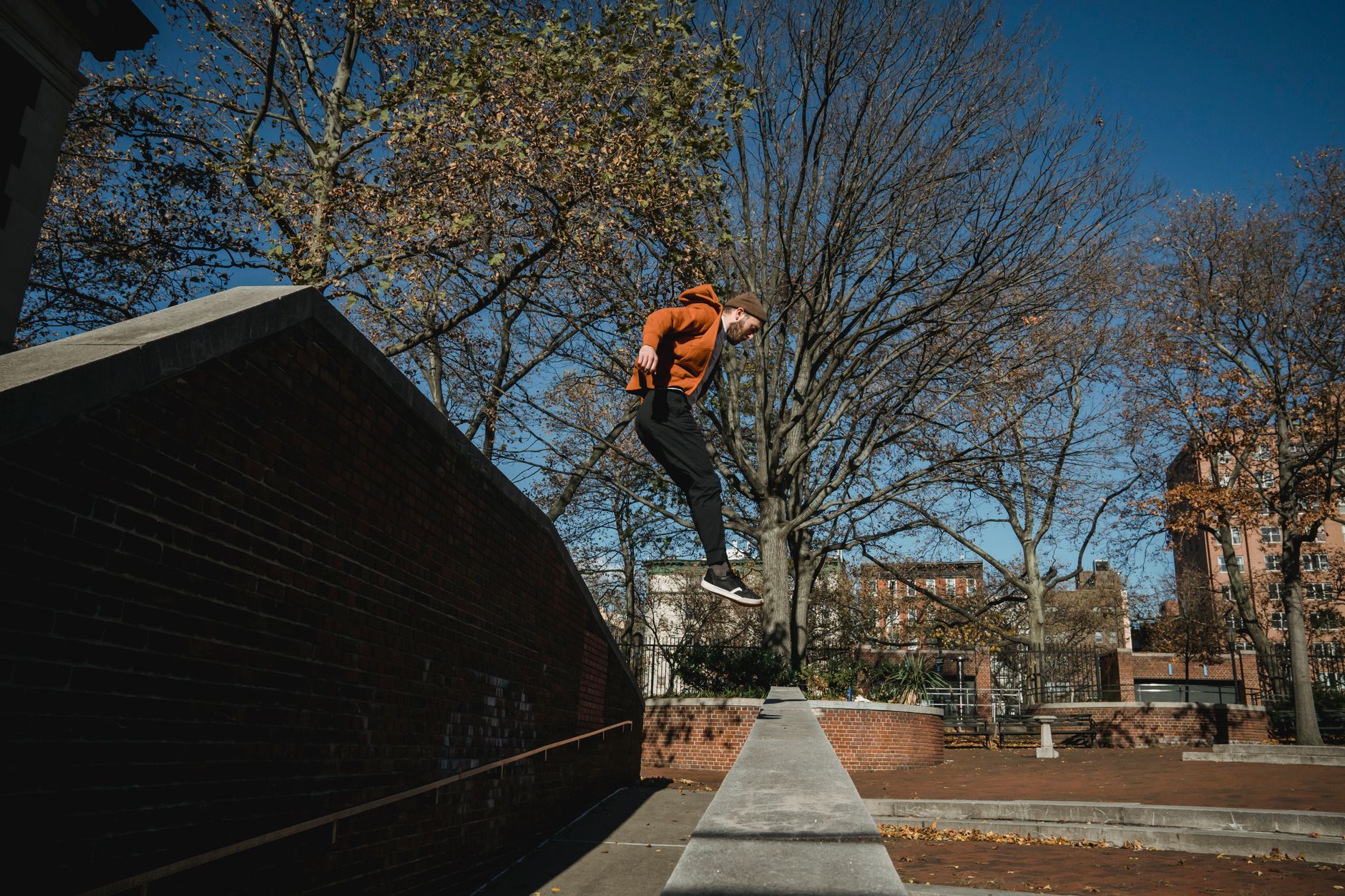 A person mid-jump between urban rooftops, reflecting the parkour gameplay central to the Dying Light series