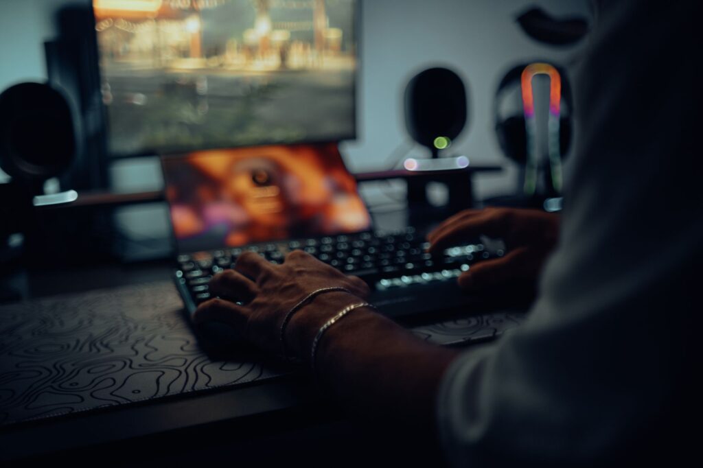 Blizzard’s Diablo IV Season Fatigue Is Reviving Path of Exile Runs A gamer sitting in front of a dark gaming setup with RGB lighting, focused on the monitor screen
