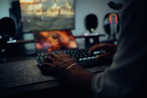 Blizzard’s Diablo IV Season Fatigue Is Reviving Path of Exile Runs A gamer sitting in front of a dark gaming setup with RGB lighting, focused on the monitor screen