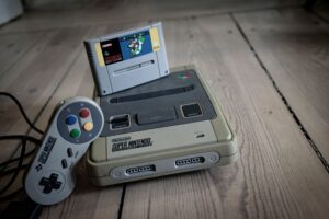 Activision’s Crash Bandicoot Silence Is Sending Fans Back to Warped A classic retro gaming console and controller on a wooden surface