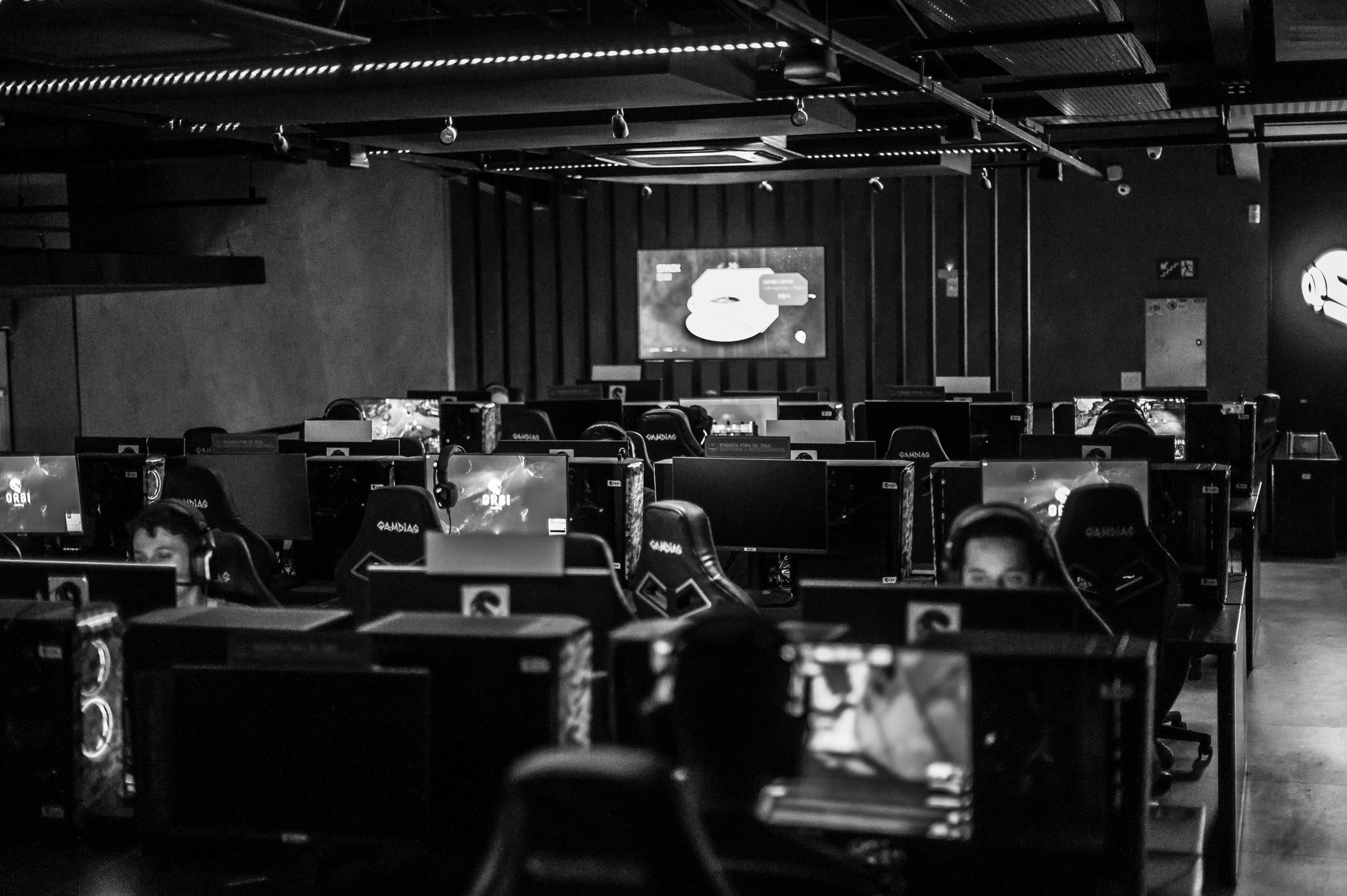 Player at a PC gaming setup with multiple monitors showing a strategy game