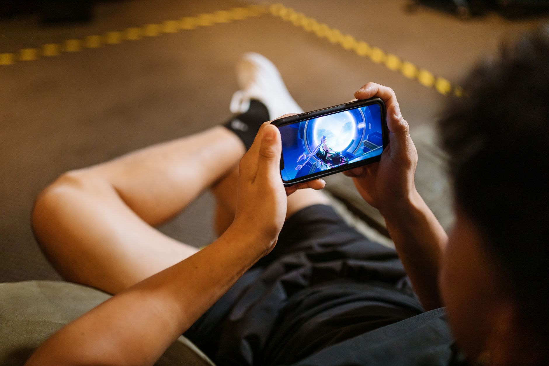 Person playing a mobile card game on a smartphone screen