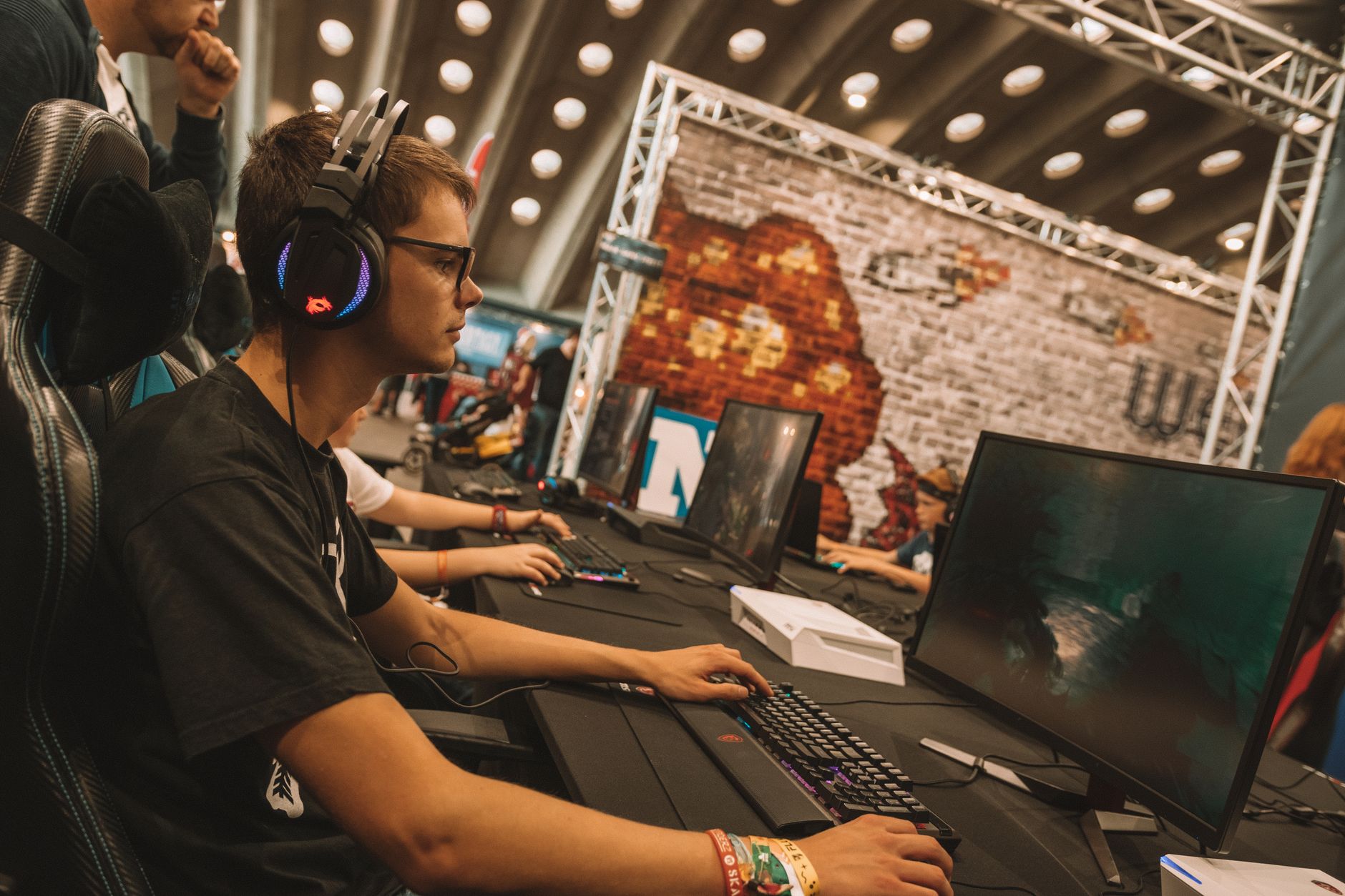 A competitive esports arena filled with screens and players, representing the fighting game tournament scene